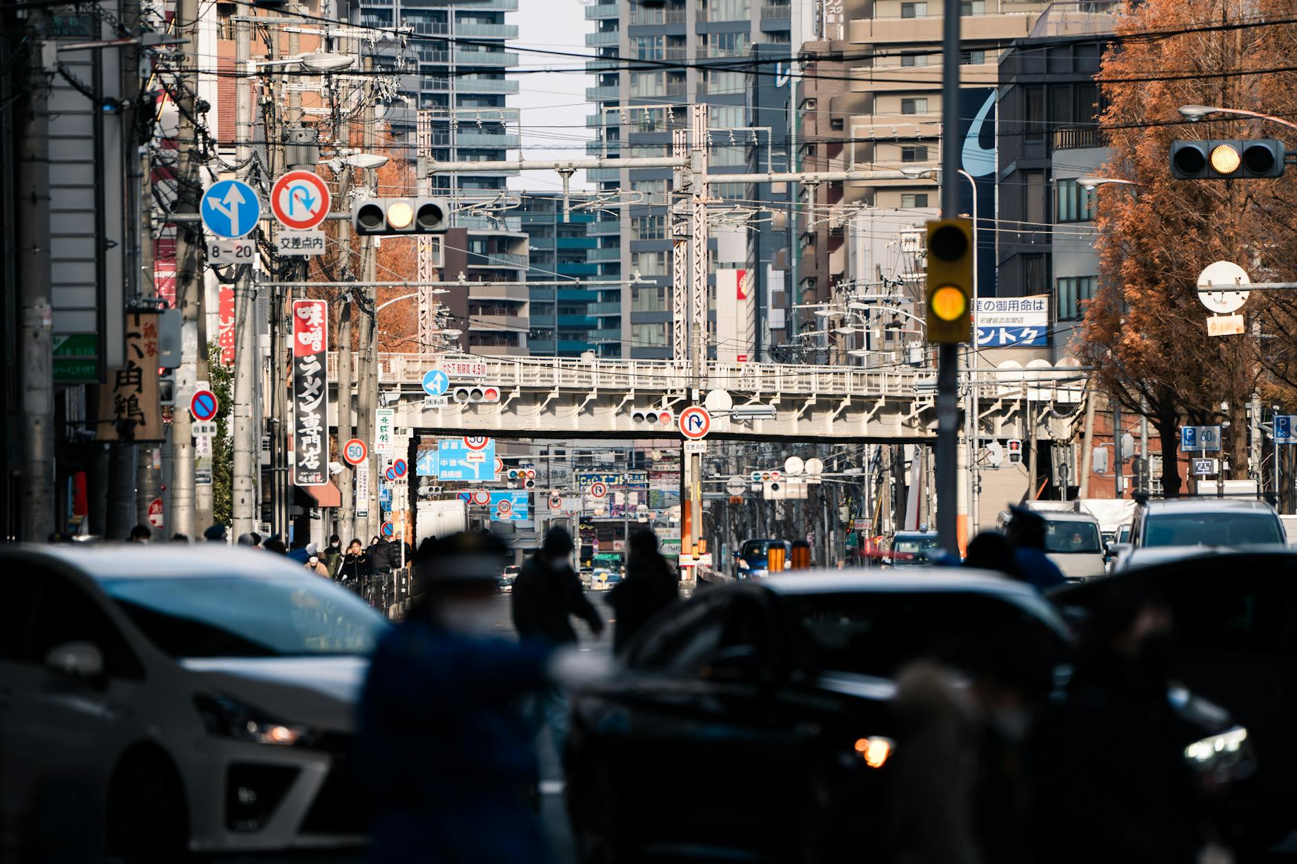 people and cars in traffic in busy city downtown