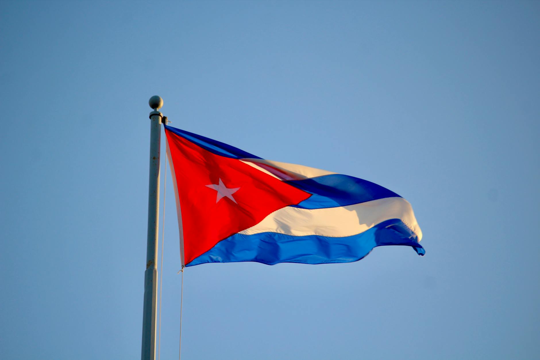cuban flag waving against blue sky